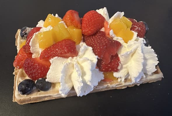 Gofr kokosanka z bitą śmietaną i owocami i polewą